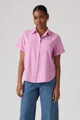 Camisa de manga corta con estampado a cuadros rosa y blanco, cuello clásico y cierre frontal con botones.