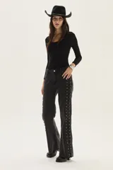 Jean de corte bootcut color negro lavado, con acordonado lateral completo en ambos lados.