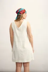 Vestido corto color negro, sin mangas, con escote en V y bolsillos laterales.