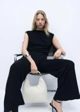 Mono largo negro de poliéster con escote drapeado, cuello Perkins, diseño recto, sin mangas, detalle fruncido en la cintura y cierre de cremallera en la parte posterior.