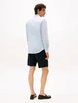 Camisa celeste de popelina con tecnología flex, corte slim, cuello abotonado, cierre con botones, manga larga y logo de Tommy Hilfiger bordado en el pecho.