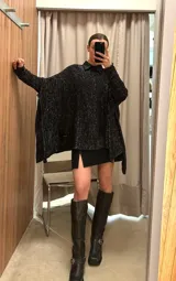 Poncho color beige de algodón tejido, con moldería oversize y tajos en los laterales.