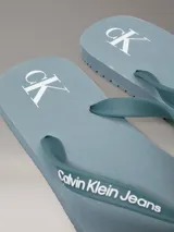 Chancletas Calvin Klein color celeste con logo de la marca en la tira.