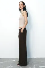Pantalón ancho gris con textura de espiga, tiro alto, doble cintura elástica ajustable con cordón, pinzas frontales, bolsillos delanteros y falso bolsillo de vivo en la espalda.