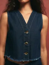 Chaleco azul oscuro de denim con botones y terminación desflecada.