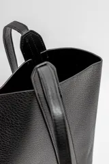 Bolso tipo tote de cuero sintético color negro, con textura granulada y doble asa de hombro.