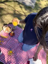 Remera azul marino de corte cuadrado con cuello redondo y manga corta. Presenta una letra 'K' estampada en color rosa en el frente.