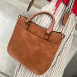 Bolso de eco cuero color marrón, con diseño estructurado y asas largas para llevar al hombro.