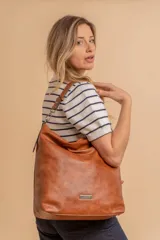 Cartera bandolera color marrón claro, de símil cuero, con dos divisiones internas, asa corta fija y correa larga regulable.