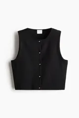 Chaleco corto de punto negro con cuello redondo y botones metálicos.