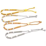 Pulsera dorada con cuentas redondas y cilíndricas con incrustaciones de strass, ajustable con cierre corredizo.