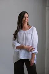 Blusa blanca de lino con mangas 3/4 y diseño de paneles con costuras a la vista.