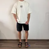 Remera negra de corte oversize y mangas cortas, con estampa en la espalda de una fotografía en blanco y negro de una persona fumando.