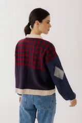Cárdigan marrón con diseño de rombos en tonos rojizos y beige. Tiene cuello redondo, cierre frontal con botones y mangas largas con puños acanalados.