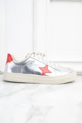Zapatillas plateadas de cuero metalizado con estrella roja en el lateral y detalles en rojo en el talón.