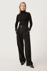 Pantalón negro de tiro alto con trabillas, bolsillos laterales y falsos bolsillos de vivo con solapa en la espalda. Detalle de cinturilla interior a contraste con pespuntes. Pinzas en el delantero. Cierre frontal con cremallera, botón interior y gancho metálico.