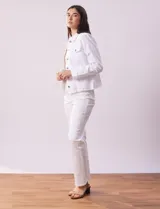 Campera de jean blanca, marca Baccini, con cuello solapa, bolsillos delanteros, abertura central con botones metálicos y terminación desflecada en el ruedo.