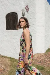 Vestido midi sin mangas con estampado floral multicolor sobre fondo negro y tajos laterales.