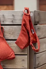 Conjunto de bikini turquesa con textura acanalada, compuesto por un corpiño triangular con argolla central y una bombacha vedetina con argollas en los laterales.