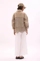 Sobrecamisa color crema con cuello camisero, cierre frontal con botones y bolsillos de parche en el pecho con apliques de crochet.