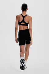 Top deportivo negro de soporte alto, confeccionado en tejido funcional ShapeMove™ y DryMove™. Cuenta con copas forradas con relleno extraíble, breteles anchos ajustables, espalda nadadora de malla y cierre de corchetes.