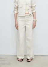 Pantalón de jean color crudo, de corte wideleg, tiro medio, con trabillas y cinturón con hebilla. Presenta cierre delantero con cremallera y botón, cuatro bolsillos y diseño largo.