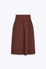 Falda midi marrón con textura, de tiro alto y cierre lateral con cremallera oculta.