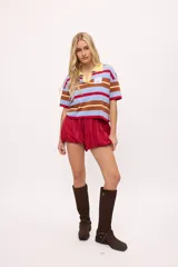 Remera tejida con rayas horizontales marrones, rosas y turquesas, cuello polo y calce boxy.