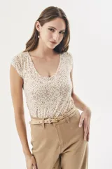 Remera blanca con estampado de lunares marrones, corte al cuerpo y mangas cortas.