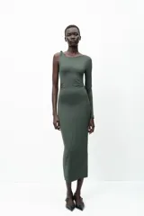 Vestido midi negro de punto, con cuello asimétrico, manga sisa, aplique metálico dorado en el hombro y drapeado lateral.