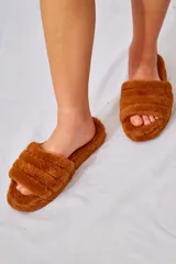 Pantuflas tipo slide forradas en piel sintética 100% poliéster, con base de goma de 4 cm.