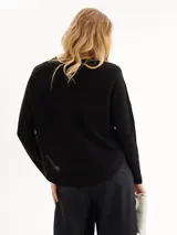 Sweater negro de punto con cuello redondo y mangas largas.
