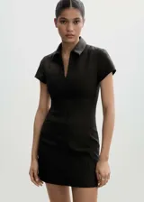 Minivestido negro de poliéster, viscosa y elastano, con cuello camisero, cierre frontal con cremallera, mangas cortas, corte entallado y costuras decorativas.
