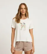 Conjunto de pijama compuesto por una remera de manga corta color blanco hueso con un estampado central de un cervatillo y una mariposa, y un short de tiro bajo color marrón topo con estampado de mini puntos blancos y ribetes blancos en los bordes.