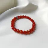 Pulsera elástica de cuentas redondas de ágata roja con un separador de acero hipoalergénico.