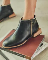 Bota corta de cuero negro con cierre lateral y suela de madera.