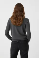 Polera de manga larga color blanco, de tejido de punto fino, con cuello tipo tortuga o cuello alto.