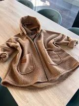 Campera negra de bouclé con cierre frontal y bolsillos de parche. Corte amplio y mangas largas.