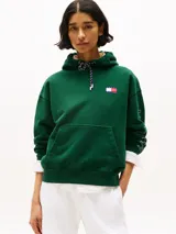 Buzo verde con capucha y cordón distintivo, bolsillo canguro, puños y bajo de punto canalé, logo oversize de Tommy Hilfiger en la manga y la parte trasera, parche con logo de Tommy Hilfiger en el pecho y detalles distintivos de Hilfiger Sailing.