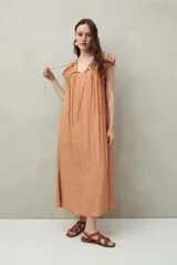Vestido largo lila con escote con lazo, mangas cortas y frunces en el pecho.
