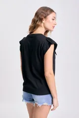 Remera negra de manga corta con cuello redondo y dos bolsillos cuadrados en el pecho.