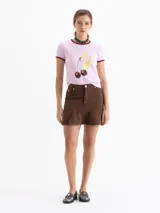 Minifalda de denim negro con cinco bolsillos tradicionales y un volado en el ruedo.