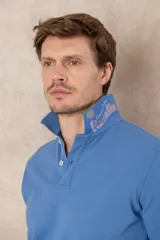 Remera tipo polo color beige, de manga corta y corte clásico. Tiene cuello con botones y está confeccionada en algodón.