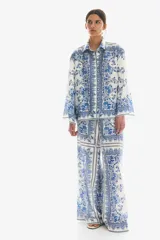 Pantalón palazzo de tiro alto con cintura elástica y cordón ajustable. Estampado paisley en tonos azules y blancos.
