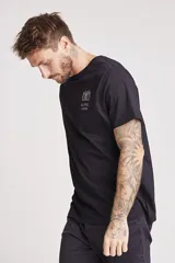 Remera negra de manga corta con cuello redondo y un pequeño estampado en el pecho que simula un radiograbador con texto.