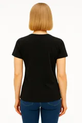 Remera negra de algodón con cuello en V y estampado frontal con la frase "Never Stop Me" en letras doradas y plateadas con estrellas.