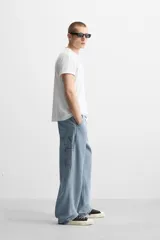 Pantalón de jean negro, corte relaxed fit, con bolsillos frontales y traseros tipo parche, tira multifunción y bolsillo tipo parche en las piernas. Tiene efecto lavado y cierre frontal con cremallera y botón.
