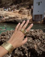 Anillo ancho de bronce con textura irregular.