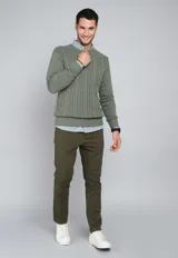 Sweater verde oliva de punto con diseño de trenzas verticales.