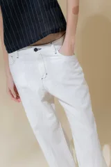 Pantalón de lino rústico color blanco, de calce recto y tiro medio. Tiene bolsillos delanteros y traseros.